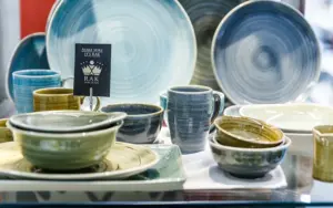 Gedeckte Tischkultur mit Tellern, Schalen und Tassen in Blau- und Grüntönen